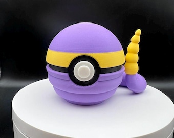 May include: A purple and yellow Poke Ball with a white button and a yellow spiral horn. The Poke Ball is made of plastic and has a textured surface.
