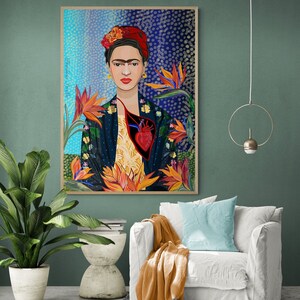 May include: A colorful painting of Frida Kahlo with a bird of paradise flower behind her. The painting is framed in wood and has a blue and white background with white dots.