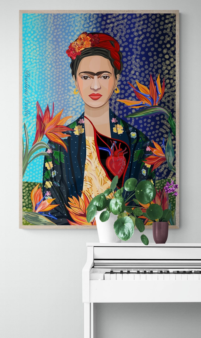 May include: A framed illustration of Frida Kahlo with a red heart and flowers. The illustration is in a blue, green, and orange color scheme. The frame is wood and has a light brown color.