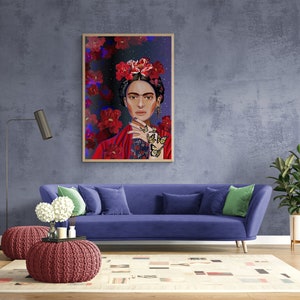 May include: A framed illustration of Frida Kahlo with a floral crown and butterflies on a blue background. The illustration is hanging on a blue wall above a blue sofa with green throw pillows.