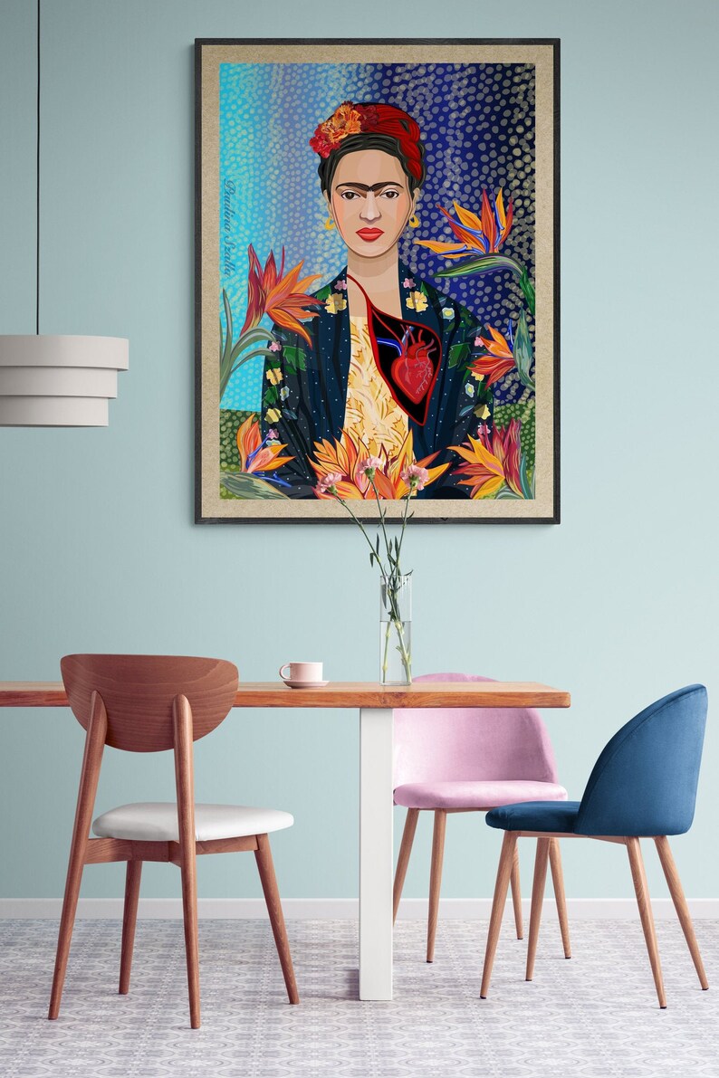 May include: A framed print of a colorful portrait of Frida Kahlo with a heart and flowers. The background is a blue and black abstract pattern.