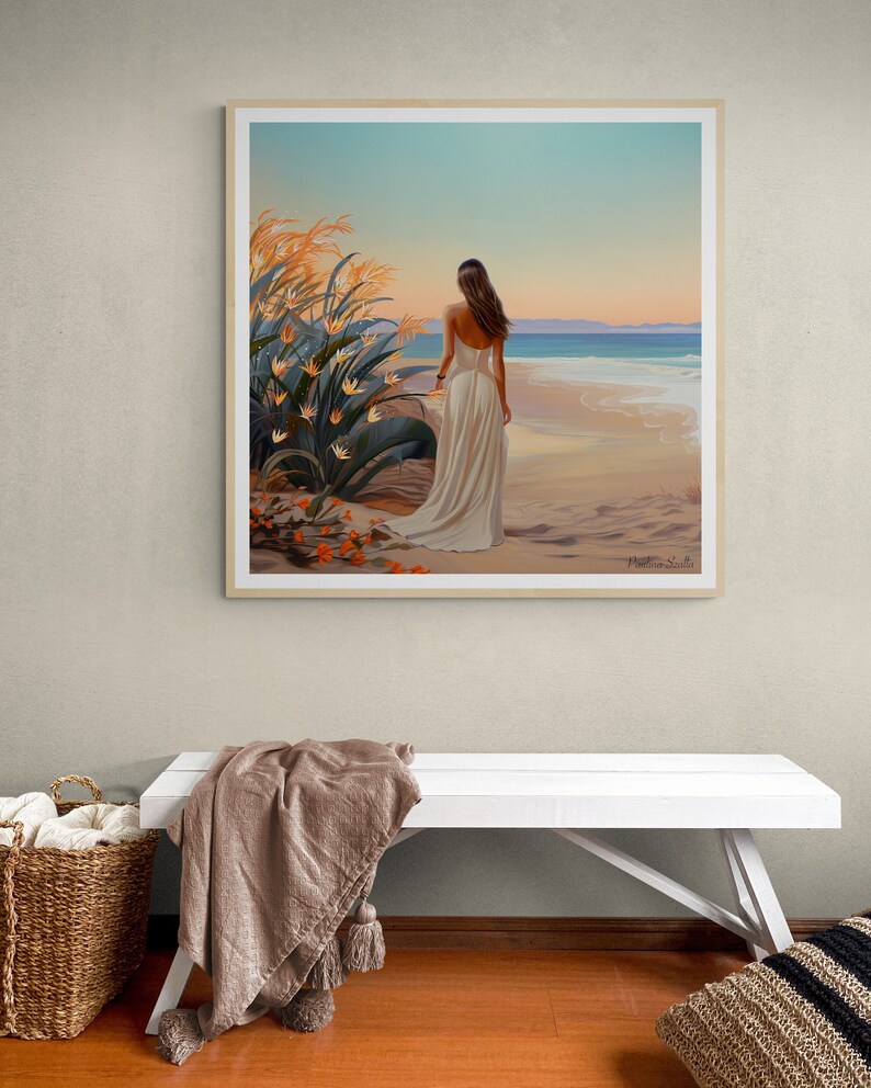 May include: A framed painting of a woman in a white dress walking on a beach with a sunset in the background. The beach is sandy and the water is blue. There are orange flowers in the foreground.