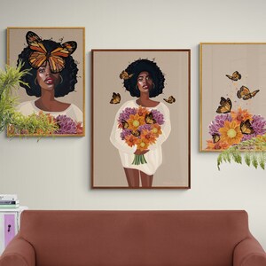 Puede incluir: Tres impresiones de arte enmarcadas que representan a una mujer con una mariposa sobre los ojos, un ramo de flores y un arreglo floral con mariposas. Las impresiones est&aacute;n en marcos dorados y tienen un fondo marr&oacute;n claro.