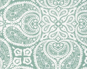 May include: Close-up of a fabric with a repeating paisley pattern in white against a muted teal background. The design features intricate floral and teardrop shapes, creating a detailed and ornate textile design. The fabric appears to be a woven material.