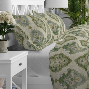 May include: A bed with a white headboard and a green and blue patterned duvet cover and pillowcases. The bedding has a damask pattern.
