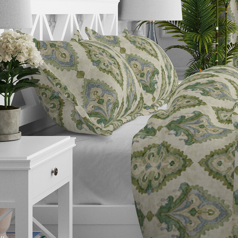 May include: A bed with a white headboard and a green and blue patterned duvet cover and pillowcases. The bedding has a damask pattern.