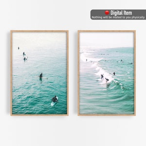 May include: Two framed prints featuring ocean scenes. One shows surfers in the water, riding waves. The other shows people on surfboards in the ocean. The water is a teal color, and the frames are light brown. The text "Digital Item" is at the top.