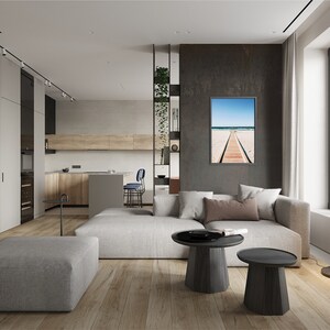 Puede incluir: Un sal&oacute;n moderno con un sof&aacute; seccional gris, dos mesas de caf&eacute; redondas de madera y una fotograf&iacute;a enmarcada de una escena de playa con una pasarela de madera que conduce al oc&eacute;ano.