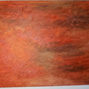 Puede incluir: Pintura abstracta sobre lienzo con una superficie texturizada. La pintura presenta una mezcla de colores naranja, rojo y marrón, creando una sensación cálida y terrosa.