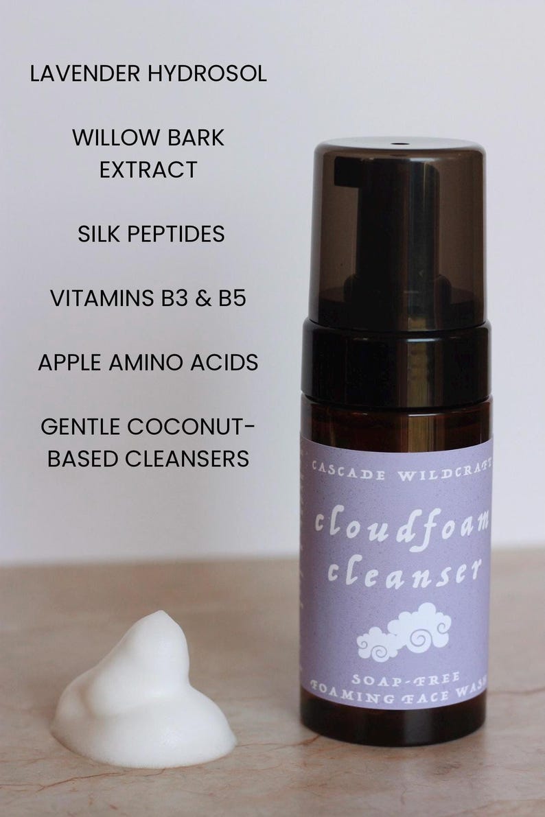 May include: A brown bottle of Cascade Wildcraft cloudfoam cleanser with a black pump top. The label is light purple with white text and a cloud graphic. A dollop of white foam sits next to the bottle. The ingredients include Lavender Hydrosol and Willow Bark Extract.