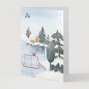 Puede incluir: Tarjeta de felicitación plegada con una escena invernal en acuarela. La imagen muestra un paisaje nevado con un estanque helado, patinadores y una red de hockey. Hay árboles de hoja perenne y casas cubiertas de nieve en el fondo. Una cometa vuela en el cielo.