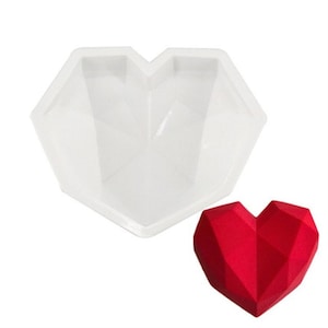 May include: White silicone heart-shaped mold with a red geometric heart made from the mold.