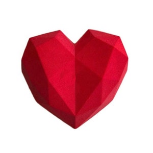 Puede incluir: Una escultura roja en forma de coraz&oacute;n, geom&eacute;trica, hecha de un material texturizado.