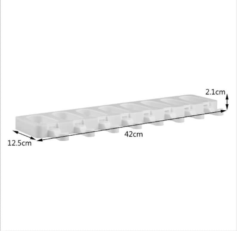 May include: White silicone popsicle mold with eight individual molds. The mold measures 12.5 inches long by 2.1 inches wide and 42 centimeters long.