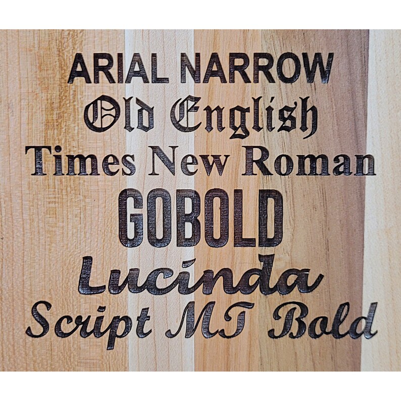 Pu&ograve; includere: Un tagliere di legno con diversi caratteri incisi su di esso. I caratteri includono Arial Narrow, Old English, Times New Roman, Gobold, Lucinda e Script MT Bold.