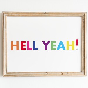 May include: A framed print with the words "HELL YEAH!" in colorful block letters. The letters are in shades of orange, red, pink, blue, purple, green, and yellow. A small smiley face is next to the exclamation point.