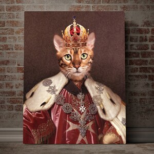 May include: A brown tabby cat wearing a gold crown and a red and white robe with gold trim. The cat is looking directly at the viewer.