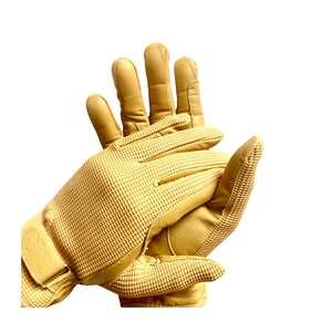 May include: A pair of tan leather gloves with a textured pattern on the back of the hand. The gloves have a wrist strap and are designed for outdoor activities.
