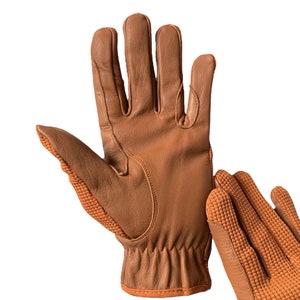 May include: A pair of brown leather gloves with a textured orange knit palm. The gloves have a long cuff and are made of a soft, supple leather.