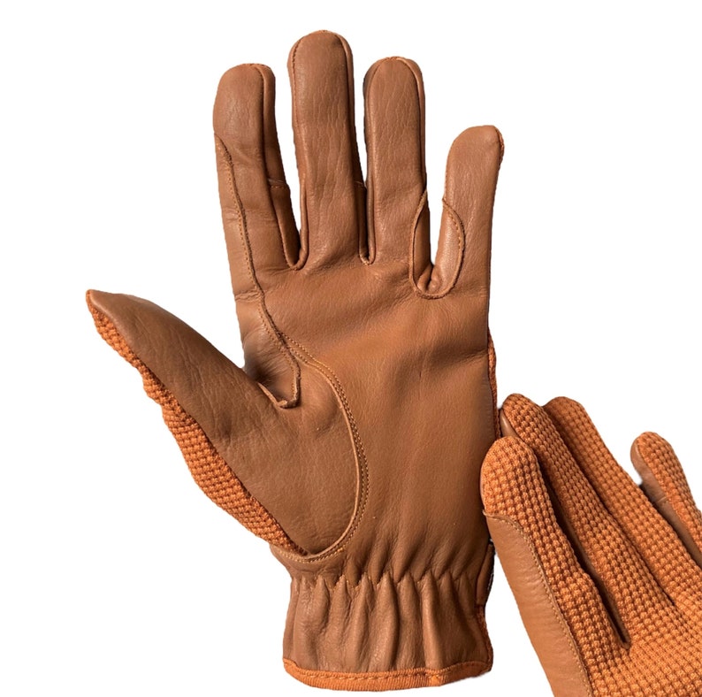 May include: A pair of brown leather gloves with a textured orange knit palm. The gloves have a long cuff and are made of a soft, supple leather.