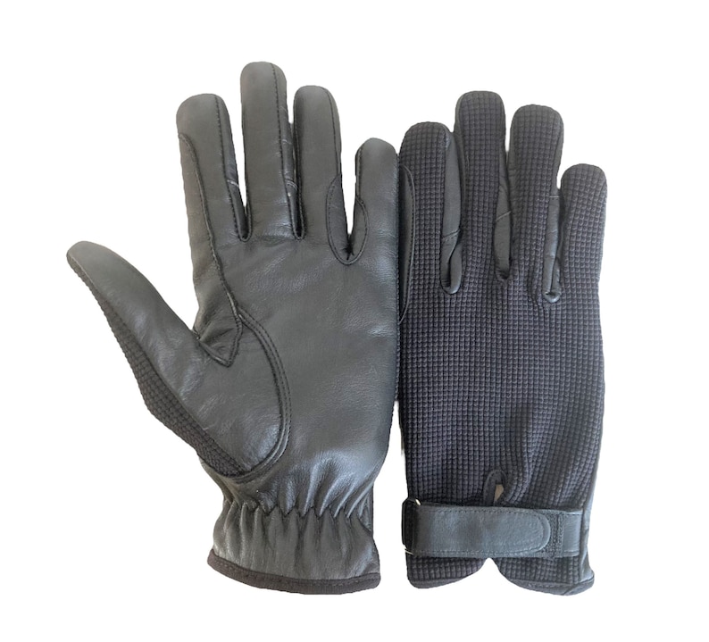 May include: A pair of black gloves, one made of leather and the other made of a textured fabric. The leather glove has a wrist strap and the fabric glove has a velcro strap.