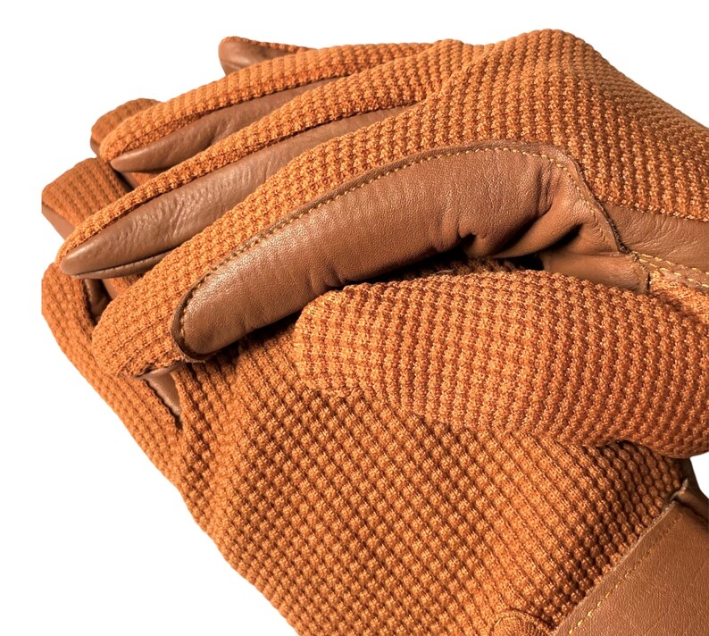 May include: A pair of brown leather and brown knit gloves with a textured knit pattern. The gloves are folded together with the leather palm facing out.