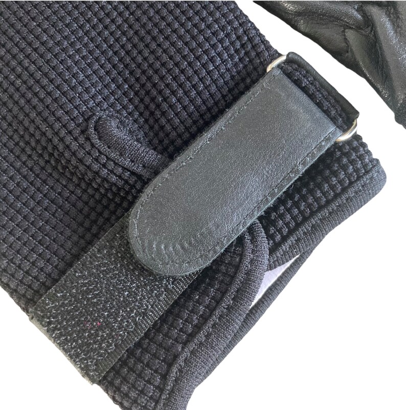 May include: Black fingerless gloves with a black adjustable strap and a silver buckle. The gloves have a textured, waffle-like pattern.