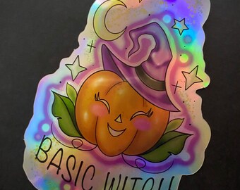 May include: A holographic sticker with a cartoon pumpkin wearing a witch's hat and the text "BASIC WITCH". The pumpkin has a smiling face and is surrounded by stars and a crescent moon.