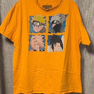 Puede incluir: Una camiseta de manga corta de color naranja brillante con un estampado gr&aacute;fico de cuatro personajes de Naruto en cuadrados individuales con borde azul. La etiqueta interior del cuello muestra el logo de Naruto y la talla XL. Cuello redondo.