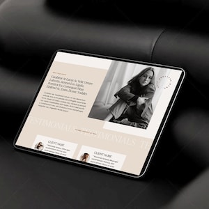 May include: A digital tablet displaying a website mockup with a beige and white color scheme. The website features text, a black and white photo of a person, and the word "TESTIMONIALS". The tablet is on a dark surface.