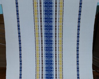 May include: White fabric with blue, yellow and brown stripes. The stripes are woven into the fabric and have a textured appearance.