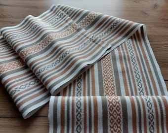 May include: A beige and brown striped fabric with a geometric pattern. The fabric is woven with a subtle texture and has a soft, natural feel.