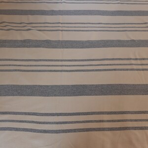 May include: A beige and gray striped throw blanket with a soft, textured feel.