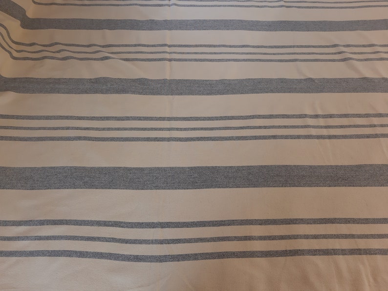 May include: A beige and gray striped throw blanket with a soft, textured feel.