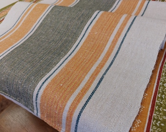 May include: A striped fabric with alternating bands of orange, white, and dark green. The fabric is woven with a textured, linen-like appearance.