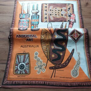 May include: A colorful fabric panel with illustrations of Aboriginal art from Australia. The panel features images of decorated spears, shields, a boomerang, bark basket, and ground drawings. The text "ABORIGINAL ART AUSTRALIA" is printed on the panel.