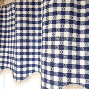 May include: Blue and white gingham valance with a scalloped edge and a white fringe trim.