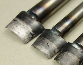 May include: Three metal leather punches with different sized tips. The tips are rounded and have a slight curve. The punches are made of metal and have a silver finish.