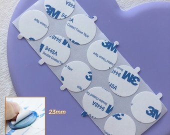 May include: A sheet of white paper with multiple round, white adhesive stickers. The stickers are 23mm in diameter and have the 3M logo and product information printed on them. The text on the stickers reads "9448A Double Coated Tissue Tape" and "94A Coated Tissue Tape".