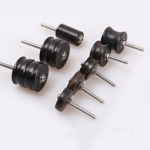 May include: Set of five wooden drawer pulls with silver screws. The pulls are in various shapes and sizes, including round, cylindrical, and oval.