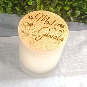 May include: A wooden candle lid with a floral design and the text "Ma Maitresse elle est Geniale".