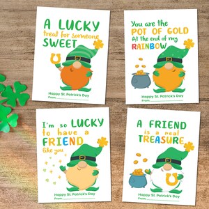 May include: Four St. Patrick's Day greeting cards with gnome illustrations. Each card has a different message in green and yellow text, such as "A LUCKY treat for someone SWEET." The cards are on a wooden surface.