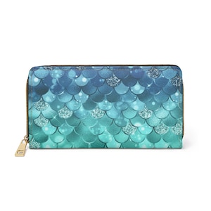 May include: A blue and green zippered wallet with a mermaid scale pattern. The scales are iridescent and have a glitter effect.