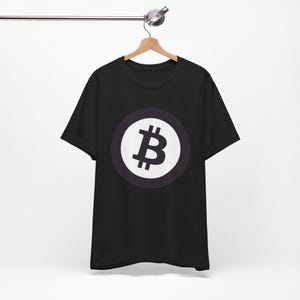 May include: Black t-shirt featuring a white circle with a Bitcoin symbol in the centre.
