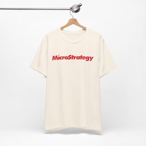 May include: A cream coloured t-shirt with a red "MicroStrategy" logo printed on the front.