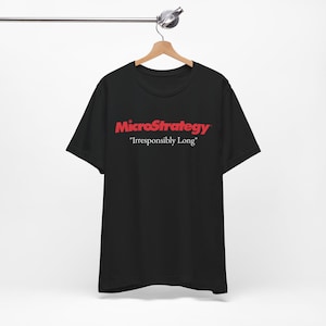 May include: Black t-shirt with the red text "MicroStrategy" above "Irresponsibly Long". The short-sleeved shirt is hanging on a wooden hanger.