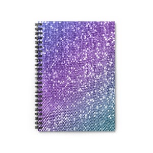May include: A spiral bound notebook with a glittery cover. The cover is a gradient of purple, blue, and green.