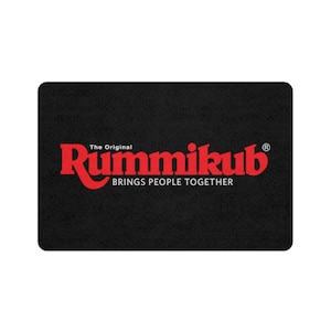 Könnte beinhalten: Schwarze Fußmatte mit dem roten Text "The Original Rummikub BRINGS PEOPLE TOGETHER" und einem eingetragenen Warenzeichen.