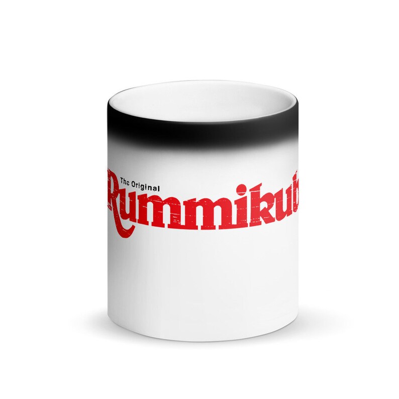 Op de afbeelding: Een witte keramische magische mok met een zwarte rand. De mok heeft de rode tekst "The Original Rummikub" aan de voorkant.