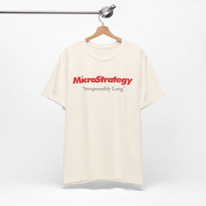 May include: A cream-coloured t-shirt with a red MicroStrategy logo and the text "Irresponsibly Long" printed on the front.